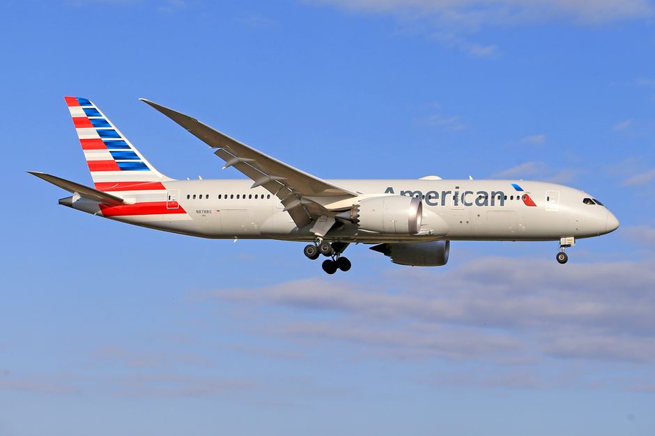 American Airlines Boeing 787 Dreamliner soaring through a clear blue sky.