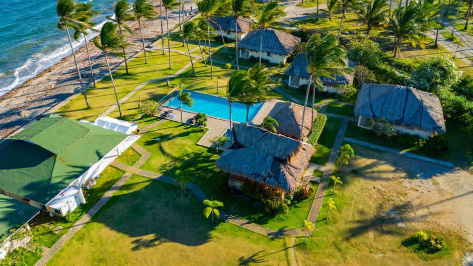 Stunning aerial view of a tropical resort in Bacong, Philippines, showcasing palm trees, beach, and swimming pool.