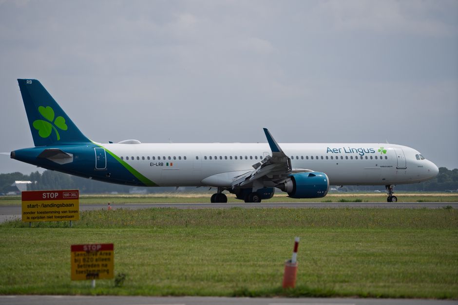 Aer Lingus Airbus A321 taxiing on airport runway in cloudy weather.