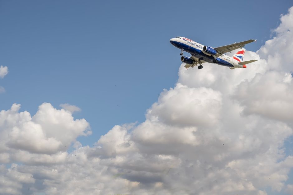 A passenger aircraft soaring through a clear blue sky above Barcelona, Spain.