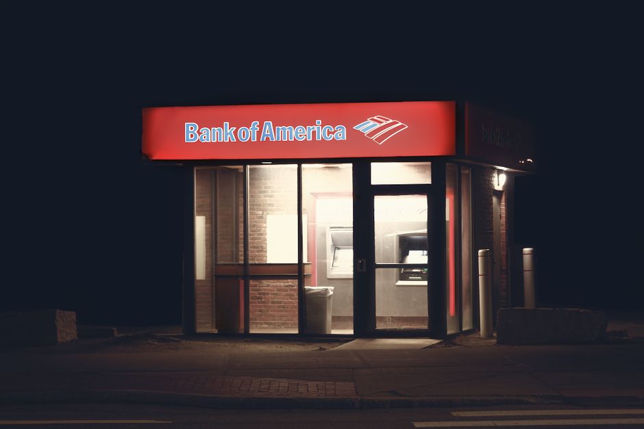 Illuminated Bank of America ATM structure against a dark nighttime backdrop in Boston.